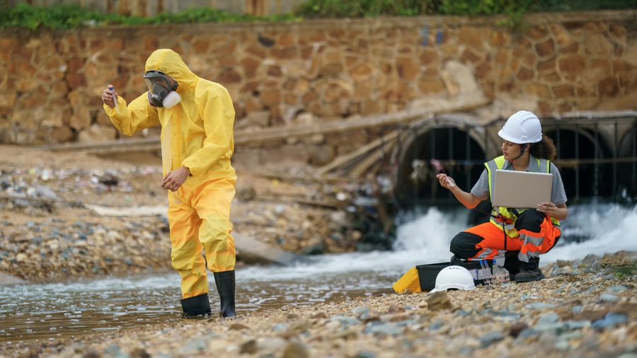 Equipe técnica coletando amostra de água contaminada para diagnóstico ambiental